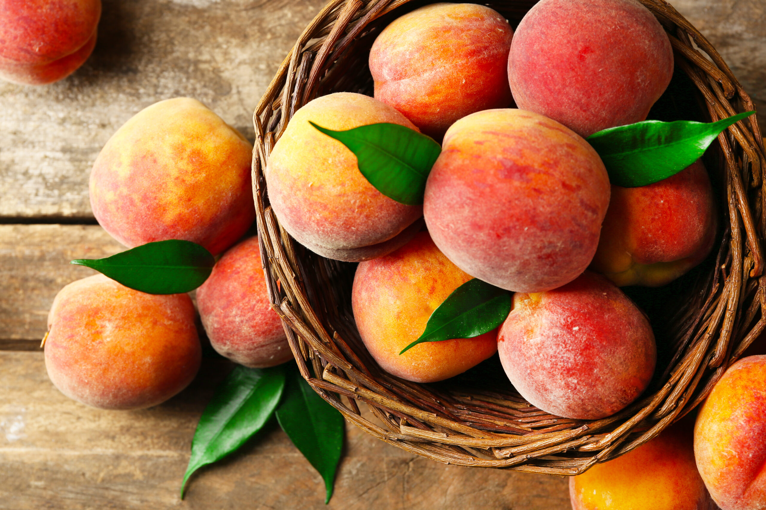 Ripe,Peaches,In,Basket,On,Wooden,Background